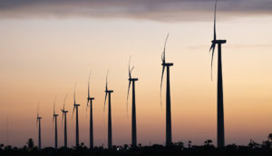Silhuetas no pôr do sol de turbinas de geração de energia eólica no Rio Grande do Norte, Brasil
