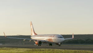 Avião da Gol pousando em aeroporto com pôr do sol, alusivo ao aumento de capital da empresa