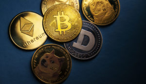 Conceito de moedas douradas de Bitcoin e Ethereum sobre mesa escura, alusivo aos impostos em criptoativos