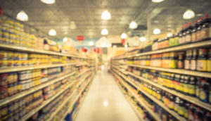Imagem de corredor de supermercado com gôndolas desfocadas, alusivo à inflação do Brasil em 2022