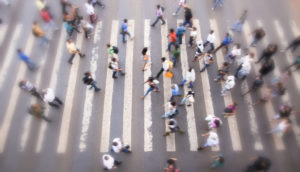 Foto de cima de pessoas em movimento sobre faixa de pedestres em cruzamento de São Paulo, alusivo ao desemprego