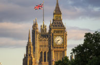 Parlamento do Reino Unido, para onde Elon Musk foi convidado a explicar transação com o Twitter, com destaque para bandeira britânica no alto e árvore à frente em primeiro plano