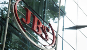 Fachada de prédio espelhado que é sede da JBS, com árvores em cima, alusivo às ações para investir em maio
