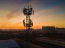 Torre de telecomunicações com pôr do sol atrás, alusivo às ações da TIM (TIMS3)