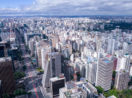 Aérea de São Paulo, com destaque para os prédios e céu azul com nuvens, alusivo à valorização dos fundos imobiliários
