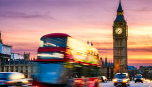 Paisagem de Londres com ônibus vermelho em movimento congelado e o Big Ben atrás, alusivo à inflação do Reino Unido