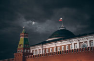 Kremlin, na Rússia, que deu calote em investidores, com bandeira do país em destaque sobre domo e céu escuro de chuva