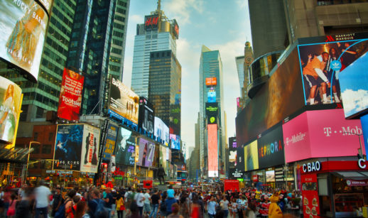 Times Square, em Nova York, durante uma tarde, com multidão caminhando, alusivo à diversificação internacional da Carteira Global em junho