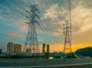 Torres de energia elétrica próximas ao Rio Pinheiros, em São Paulo, com pôr do sol ao fundo, alusivo à privatização da Eletrobras