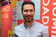 Felipe Oliva, CEO da Squid, sorrindo, de camisa branca com mural atrás colorido