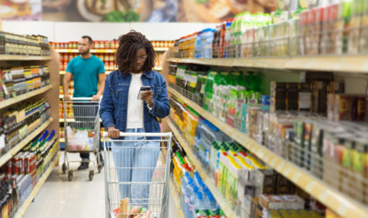 Mulher em primeiro plano e homem logo atrás, ambos com carrinhos dentro de supermercado, alusivo à inflação dos EUA registrada em maio