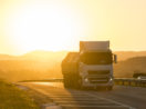 Caminhão rodando em estrada com pôr do sol ao fundo, alusivo ao crescimento dos serviços em maio