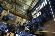 Interior do Goldman Sachs, com destaque de painel de acrílico com logo do banco em branco