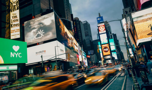 Times Square, em Nova York, à noite, com movimento em freezee, alusivo ao crescimento dos EUA e da Europa