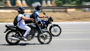 Duas motos com motociclistas em cima, em movimento, alusivo ao aumento da produção em julho