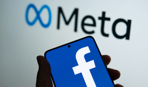 Tela de celular aberto com o logo gigante do Facebook e, atrás, o logo da Meta, que fez acordo para encerrar o caso da Cambridge Analytica