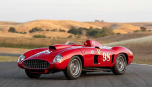 Ferrari 410 Sport Spider de 1955, líder da lista de carros mais caros leiloados em Monterey, nos EUA, na cor vermelha, parado em estrada com vales atrás