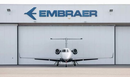 Avião da Embraer em frente a hangar com destaque para o letreiro da empresa, que teve lucro