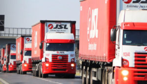 Caminhões da JSL (JSLG3), nas cores vermelha e branca, enfileirados em rodovia