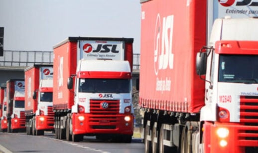 Caminhões da JSL (JSLG3), nas cores vermelha e branca, enfileirados em rodovia