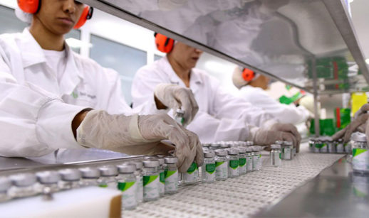 Linha de produção de farmoquímicos, com destaque para mãos de funcionários em frascos, o setor que puxou a queda da produção industrial de junho