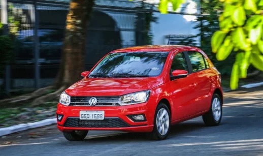 Volkswagen Gol, líder entre os carros mais vendidos do Brasil em agosto, na cor vermelha, em movimento em rua ensolarada