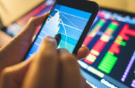 Homem analisa gráfico do mercado financeiro no celular
