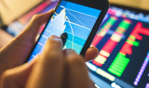 Homem analisa gráfico do mercado financeiro no celular