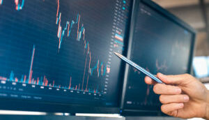 Investidor analisa gráfico de ações em tela de computador