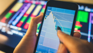 Investidor analisa gráfico do mercado financeiro em celular