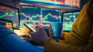 investidor analisa gráficos do mercado financeiro em um celular