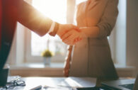 duas pessoas apertam as mãos, simulando um acordo para credenciar escritório de investimentos